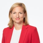 Frau in rotem Blazer vor weissem Hintergrund.