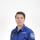 Portrait einer Polizeibeamtin in Uniform vor weissem Hintergrund.