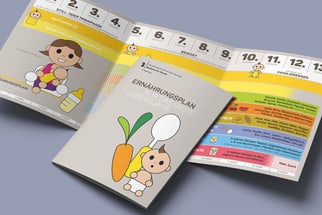 Broschüre mit Baby-und Gemüse-Illustrationen auf einem Tisch.