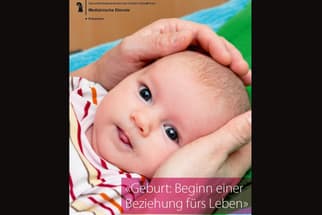 Nahaufnahme eines Babys, das in den Händen gehalten wird.