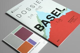 Broschüre und Karte mit Basel-Design auf grauem Hintergrund.