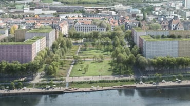 Luftbild eines Parks inmitten von Gebäuden am Flussufer.