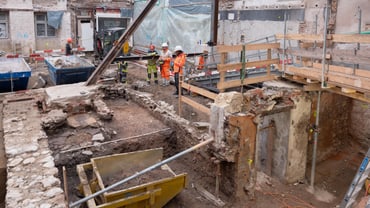 Baustelle mit Bauarbeitern und Gerüsten.