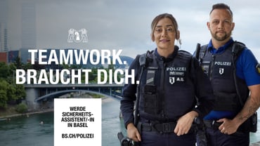 Zwei Polizisten vor einem Fluss mit Brücke.