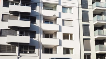 Moderne Wohngebäude mit geparkten Autos davor.