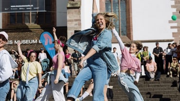 Eine Gruppe junger Frauen tanzt auf dem Barfüsserplatz.