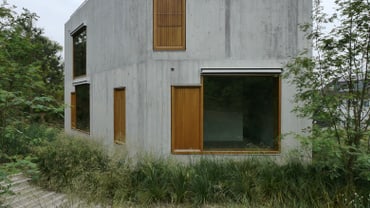 Ein modernes leeres Haus in einer üppigen Graslandschaft.