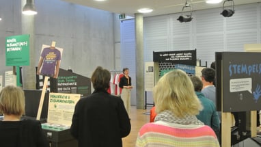 Menschen betrachten eine Ausstellung in einem modernen Gebäude.