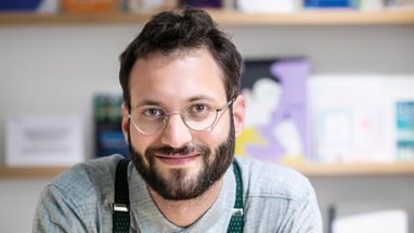 Mann mit Brille im Innenraum.