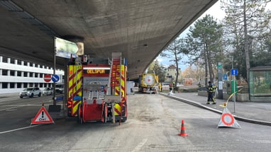 Ölspurbeseitigung unter Brücke mit Einsatzfahrzeugen und Absperrung.",