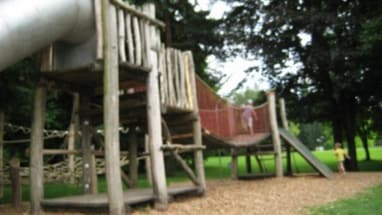 Spielplatz mit Rutschen und Klettergerüsten im Park.