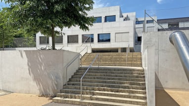 Treppe zu modernem Gebäude mit Baum.