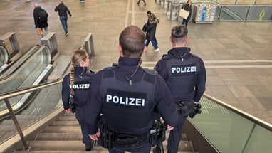 Polizisten gehen Treppe in Bahnhof hinunter.