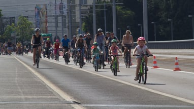 Die Wettsteinbrücke mit dem Kunstmuseum im Hintergrund und Fahrradfahrerinnen- und fahrer, die die Brücke runterfahren. 