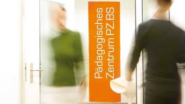 Eingang zum Pädagogischen Zentrum PZ.BS mit zwei unscharfen Personen.