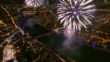 Feuerwerk über dem Rhein. Die beleuchtete Stadt Basel bei Nacht aus der Vogelperspektive.