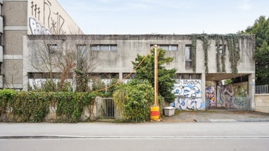 Verlassenes Gebäude mit Graffiti und Efeu bewachsen.