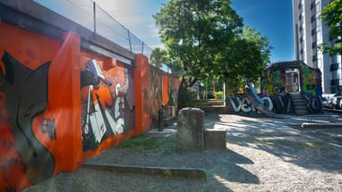 Städtische Szene mit Graffiti-Wänden und Bäumen.