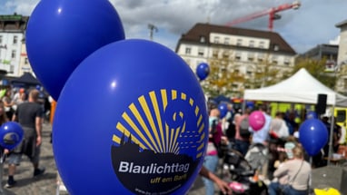 Blaue Blaulichttag-Ballone auf belebtem Barfüsserplatz am 13. September 2025