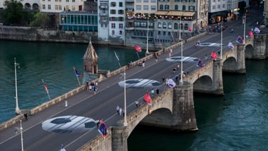 Historische Brücke über Wasser mit Flaggen und Fussgängern.