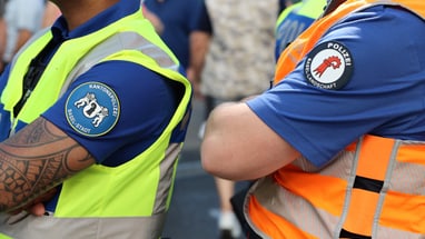 Polizisten in gelben und orangefarbenen Westen bei einer Veranstaltung.