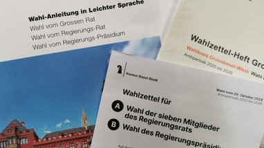 Verschiedene Wahlzettel und Anleitungen zur Abstimmung in Basel.