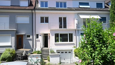 Reihenhäuser mit Fahrrädern und Autos davor.