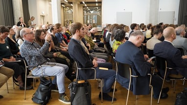 Menschen sitzen in einem Konferenzraum.