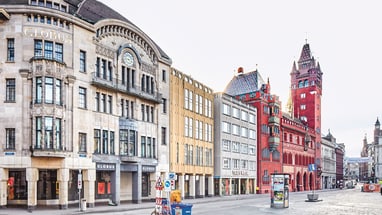 Strassenszene mit historischen Gebäuden und Turm in Basel.