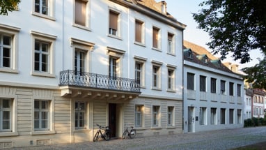 Historisches Gebäude mit Balkon und Fahrrädern davor.