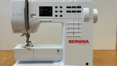 Elektrische Nähmaschine auf Holzoberfläche.