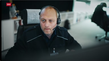 Mann mit Headset sitzt konzentriert vor einem Bildschirm in der Rettungszentrale.