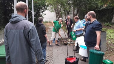 Gruppe von Menschen bei Gartenarbeit.