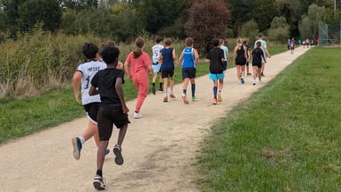 Gruppe von Kindern läuft auf einem Weg im Freien.