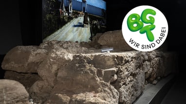 Römische Ruinen mit digitalem Hintergrundbild, BGT-Logo eingeblendet.