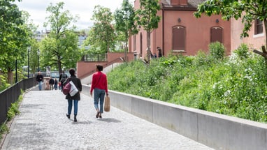 Zwei Personen spazieren auf einem attraktiven Weg in der Stadt Basel.