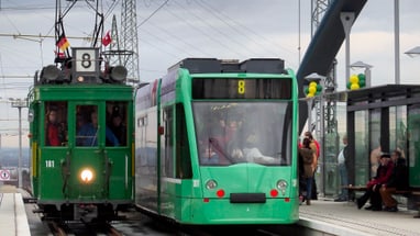 Foto der Haltestelle Weil am Rhein Bahnhof/Zentrum am Bahnhof Weil am Rhein anlässlich der Eröffnung der Tramlinie 8 im Jahr 2014. Auf dem Bild steht an der Haltestelle ein neues Tram der Linie 8 neben einem Tram der Oldtimer-Flotte.