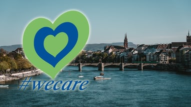 Herzlogo mit #wecare über Fluss und Stadtansicht.