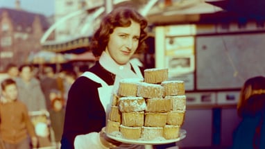 Frau mit einem Teller «Rosekiechli» an der Basler Herbstmesse, 1950er Jahre.
