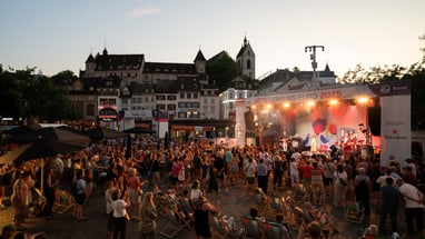Freiluftkonzert mit Menschenmenge in der Abenddämmerung in der Stadt.