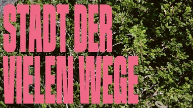 Rosa Text 'Stadt der vielen Wege' auf grünem Hintergrund.