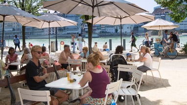 Menschen unter Sonnenschirmen am Rhein