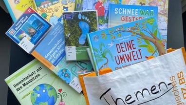 Bücher, CDs und Broschüren zum Thema Umwelt auf einem Tisch.