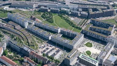 Luftaufnahme von Wohngebäuden und Grünanlagen in urbanem Bereich."  