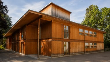Holzgebäude mit Bäumen im Hintergrund.