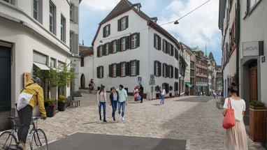 Belebte Kopfsteinpflasterstrasse mit Personen und Fahrradfahrer in Altstadt.",