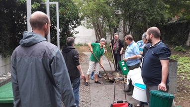 Gruppe von Menschen beim Kompostieren im Freien.