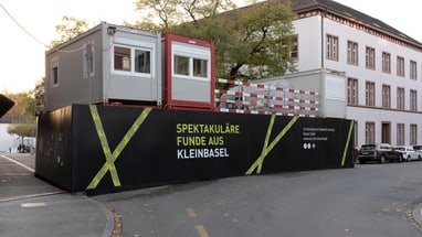 Baustelle mit Containern und Plakat in Kleinbasel.",