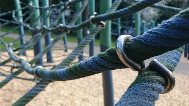 Nahaufnahme von Kletternetzen auf einem Spielplatz.",