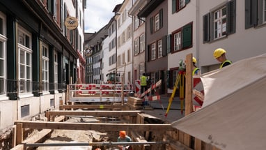 Strassenszene mit dem Team der Archäologischen Bodenforschung bei einer Baustelle.